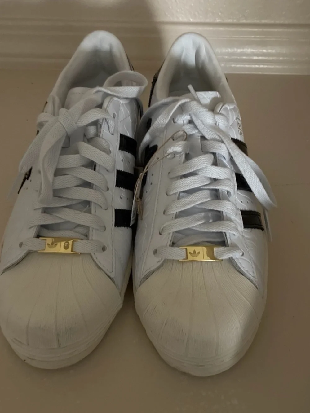 Bape White Sneakers with Black Stripes and Gold Tongue Accents